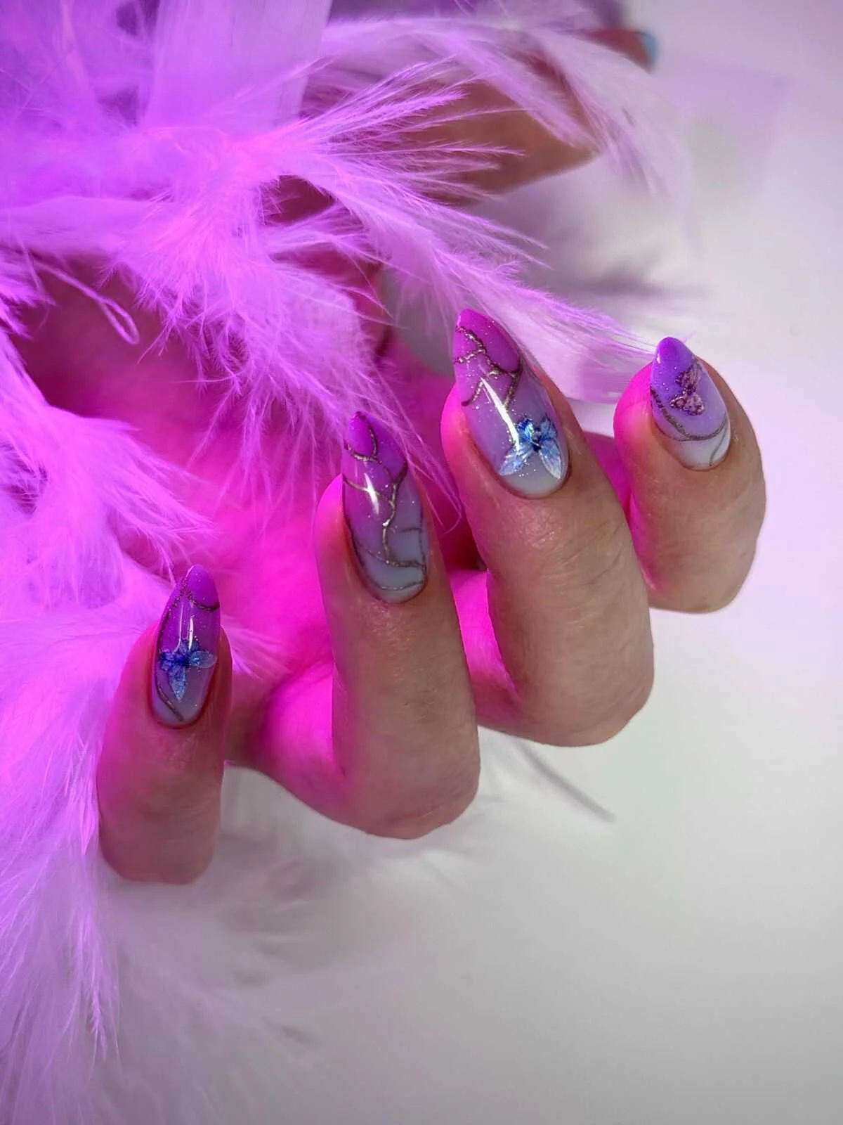 Purple butterfly nail art with metallic details